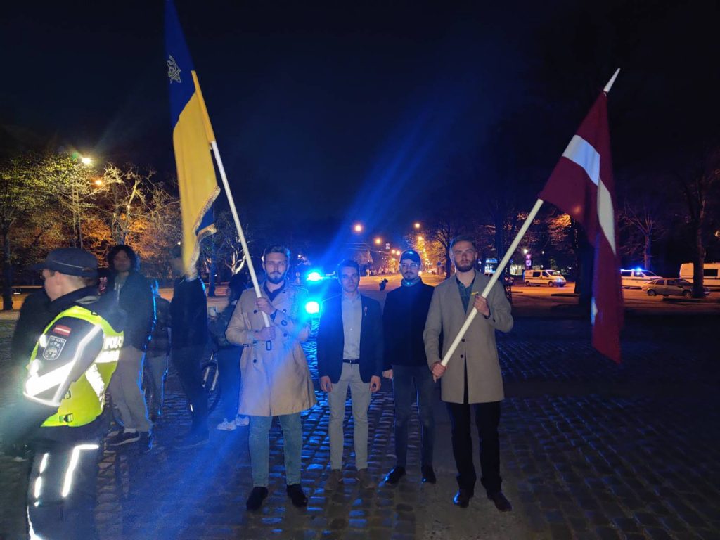 vīri ar Latvijas un Ukrainas karogiem