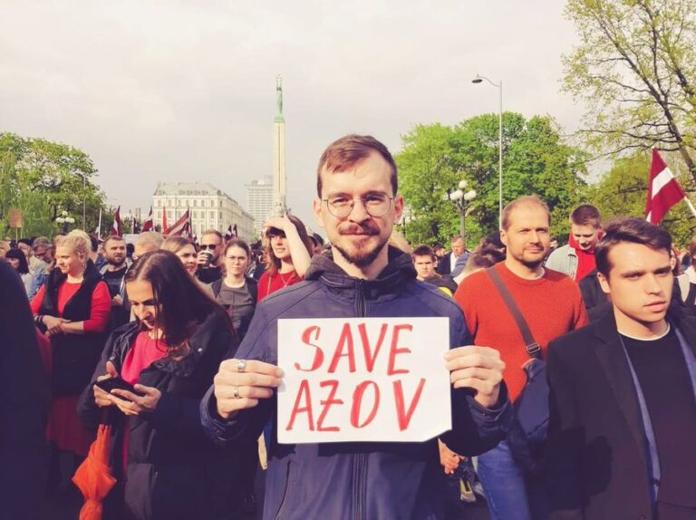 Raksta autors gājienā, rokās turot uzrakstu Save Azov